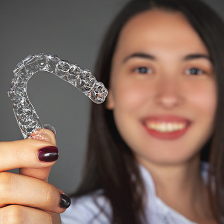 Woman holding up clear retainer