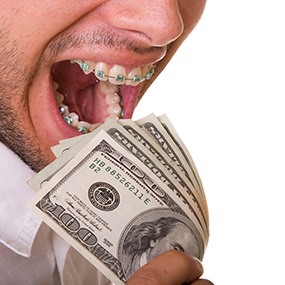 Man with braces eating a wad of hundred-dollar bills