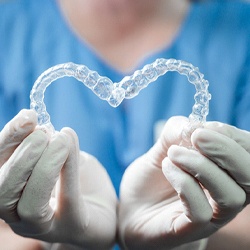 Close up of dentist holding two Invisalign aligners