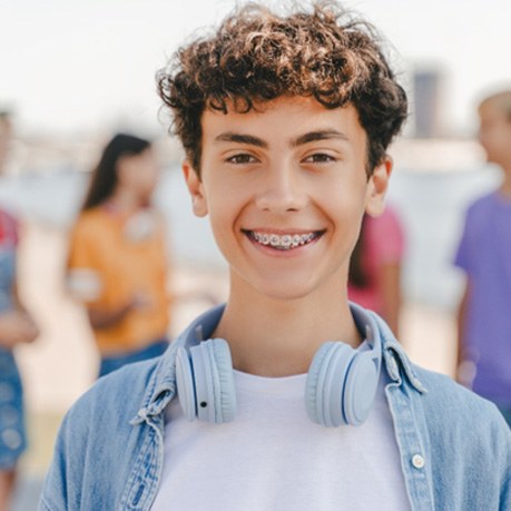 Young boy with braces smiling at beach