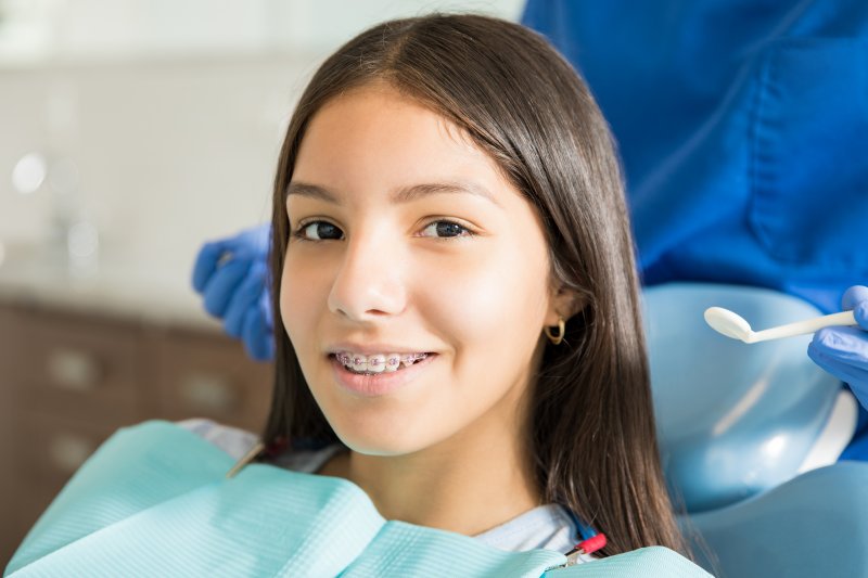 a young girl with braces smiling in preparation for seeing her orthodontist in Cumming, GA 