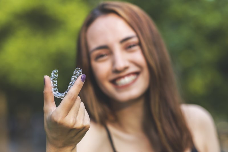 a closeup of a patient holding Invisalign