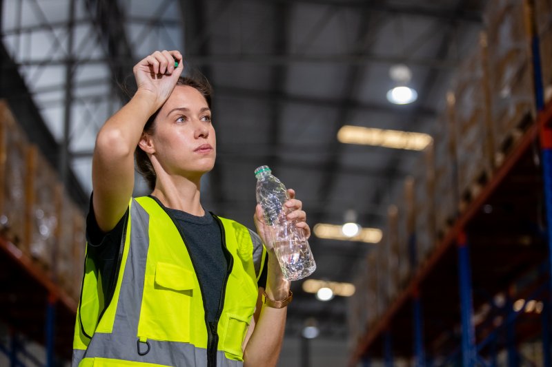 Thirsty worker holds water bottle.