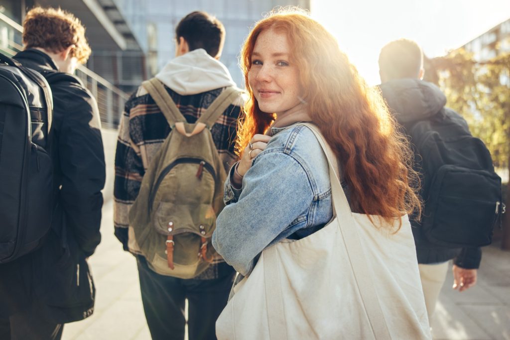 Closeup of teen smiling while walking around campus with friends