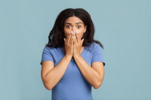 Shocked, worried woman covering her mouth