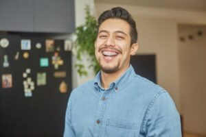 Man with braces smiling while getting his photo taken