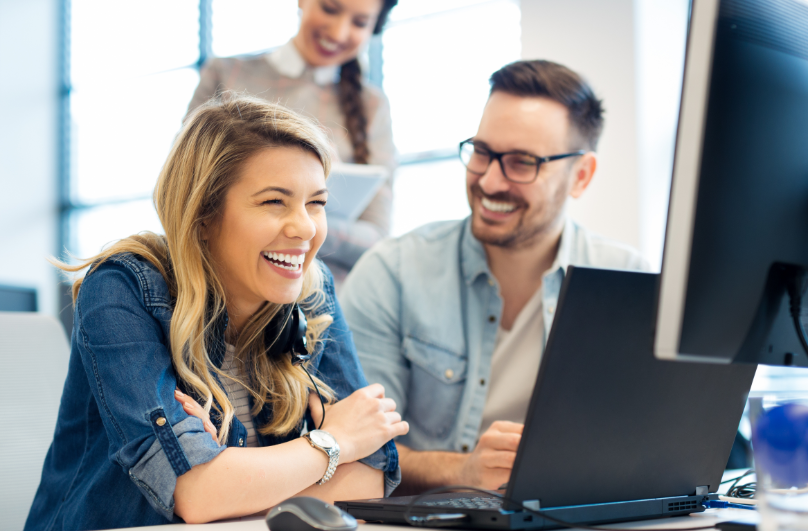 Office workers around a laptop